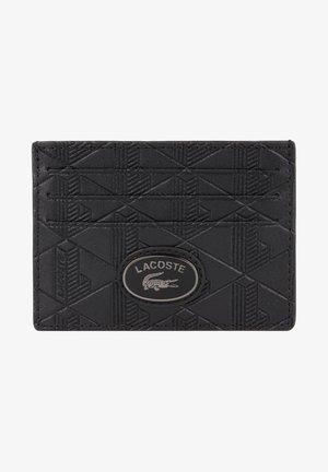 Tarjetero de cuero negro con un patrón geométrico texturizado, que presenta un prominente logo ovalado de Lacoste y múltiples ranuras para tarjetas.