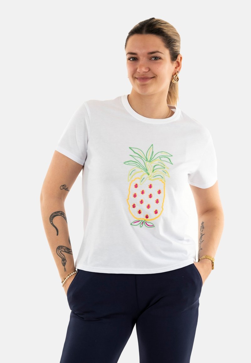 Camiseta blanca de algodón con un diseño bordado de piña en tonos rojos, verdes y amarillos. Mangas cortas y un corte relajado.