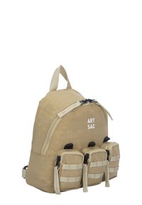 Tan färgad ryggsäck med rundad form, dragkedjestängning, framlogotyp "ART SAC" och tre små fack med remmar.