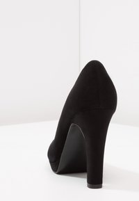 Černý semišový vysoký podpatek, špičatý tvar, hladká textura, s vymezeným podpatkem a minimalistickou siluetou.