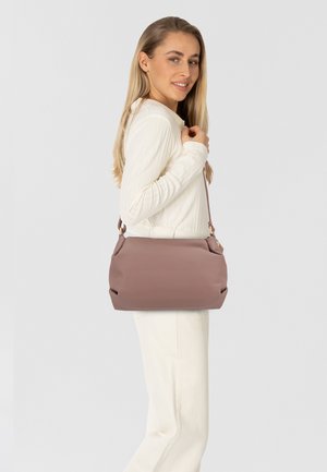 Helllila Leder-Umhängetasche mit strukturiertem Design, oberem Reißverschluss und verstellbarem Trageriemen, vor einem neutralen Hintergrund präsentiert.