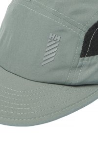Gorra verde claro de tela con un acento negro texturizado y un detalle de logo gris. Presenta costuras visibles y un ala redondeada.