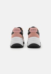 Svarte og rosa joggesko med en kraftig hvit såle; har sukkersvart aksenter, logo på hælen og teksturert gummi yttersåle.