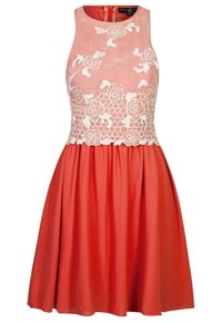 Šaty bez rukávů s korálovou sukní a růžovým korzetem, které mají bílé květinové krajky a texturovanou tkaninu. Zapínání na zip na zadní straně.