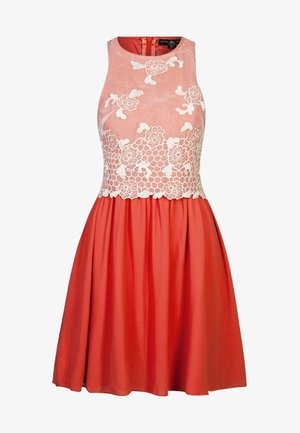 Punainen mekko, jossa on vartalonmyötäinen ilman hihoja oleva yläosa, jossa on kukkavillakuvioita, levenevä helma ja sileä pinta, yhdistetty mustaan clutch-laukkuun.