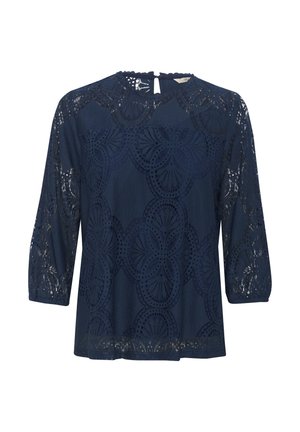 Tengerészkék csipkés felső, 3/4-es ujjal, kerek nyakkivágással, bonyolult kivágott mintázattal és egy kis hátulsó kulcslyuknyílással.