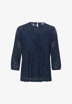 Top en dentelle bleu marine avec des manches trois-quarts, un col rond, des motifs découpés complexes et une petite ouverture en forme de clé dans le dos.