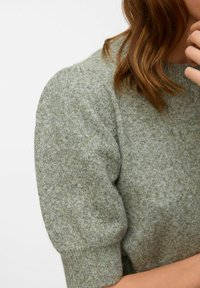 Maglione lavorato a maglia in verde morbido e tenue, con maniche corte a sbuffo e scollatura a girocollo. Presenta una finitura testurizzata e polsini a coste.