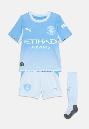 Manchester Cityn lasten jalkapallovarusteissa vaaleansininen liukuvärinen paita, valkoiset shortsit ja vaaleansiniset sukat, joissa on Puman logot ja Etihad Airwaysin sponsorointi.