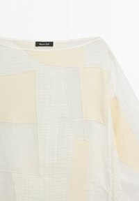 Biały i beżowy patchworkowy dzianinowy top z dekoltem typu łódka i długimi rękawami, z metką Massimo Dutti wewnątrz kołnierza.