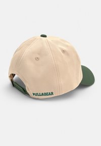 Căciulă de baseball bej cu vizieră verde și curea ajustabilă. Prezintă un logo brodat "FULL&BEAR" pe spate. Material din bumbac.