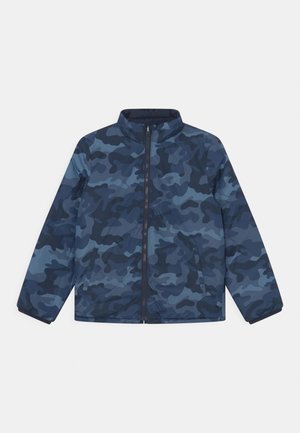 Veste zippée à motif camouflage bleu et bleu foncé, manches longues et col montant, posée à plat sur fond blanc.