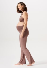 Zwangerschapsoutfit met een aansluitend, zacht bruin tanktop en bijpassende flared leggings, ontworpen voor comfort tijdens de zwangerschap.
