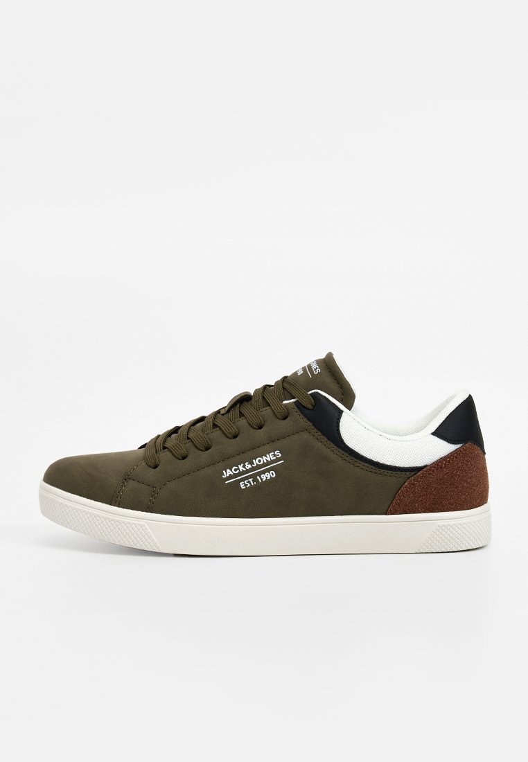 Sneaker vert olive avec une tige en tissu lisse, des accents blancs et noirs, un talon en daim brun, un détail de logo et une semelle en caoutchouc texturé blanche.