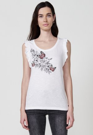 Weißes ärmelloses Shirt mit Rüschenecken, verziert mit schwarzer und roter floral und Schmetterlingsstickerei auf der linken Seite. Weicher, leichter Stoff.