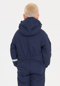 Mørkeblå børneoveralls med hætte, elastisk talje og refleksstribe langs ærmet. Glat, vandafvisende materiale.