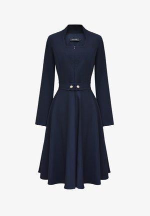Granatowa sukienka z długimi rękawami, dopasowanym korpusem, ściągniętą w taliach, ozdobiona dwoma guzikami, z rozkloszowanym dołem i bez kołnierzyka.