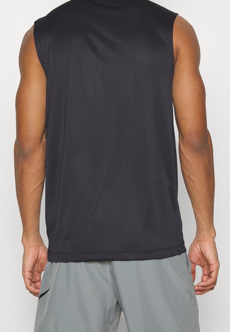 Czarny bezrękawnik sportowy wykonany z gładkiego materiału, o swobodnym kroju i zaokrąglonym dolnym wykończeniu. Widoczne szwy, bez graficznych wzorów.