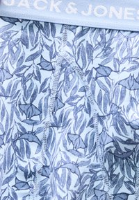 Λωρίδα μέσης εσωρούχου με την ετικέτα "JACK & JONES", υφασμένος με μοτίβο από μπλε και λευκά φύλλα και σκορπιούς, με ορατές λεπτομέρειες ραφής.