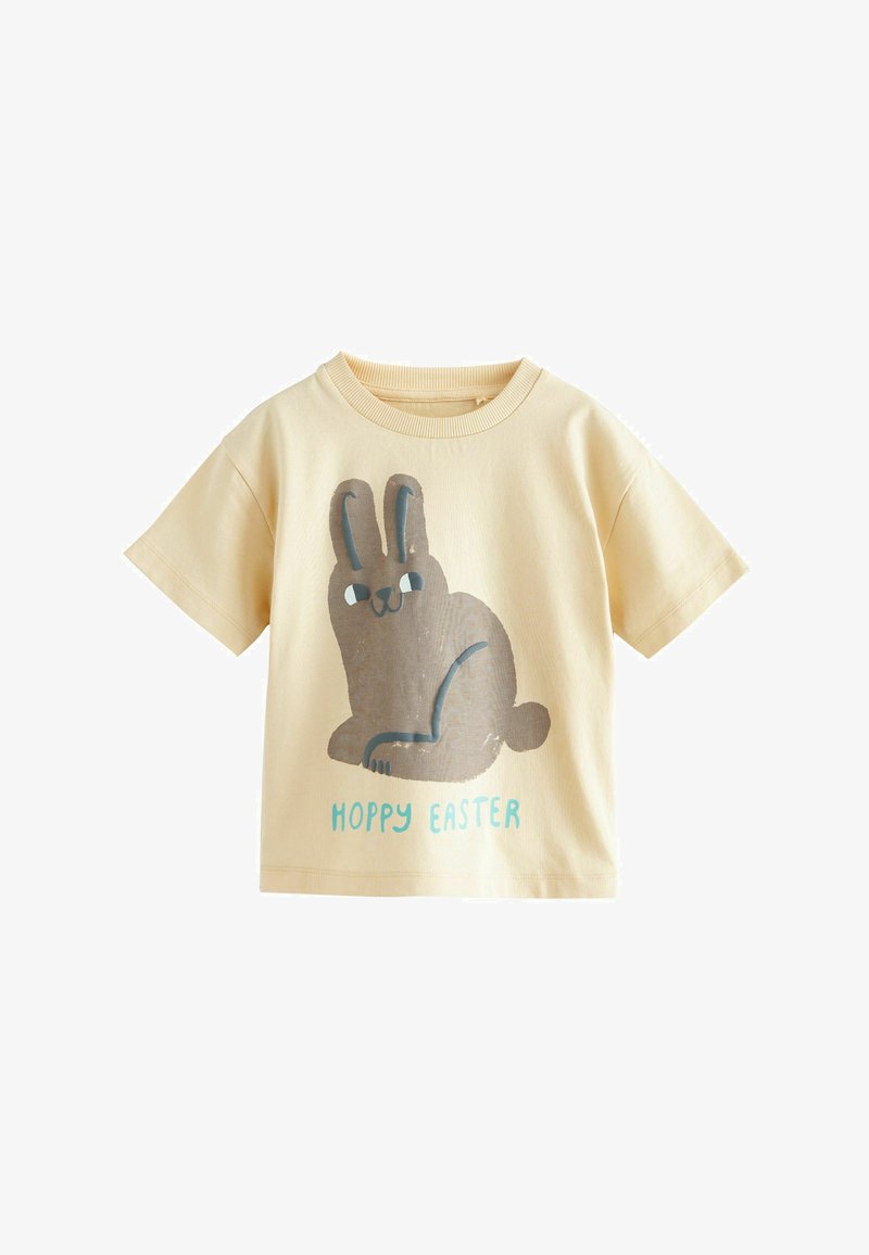 Cremefarbenes T-Shirt mit kurzen Ärmeln, großer grauer Hasenillustration und blauem Text mit dem Schriftzug "HOPPY EASTER" auf der Vorderseite.