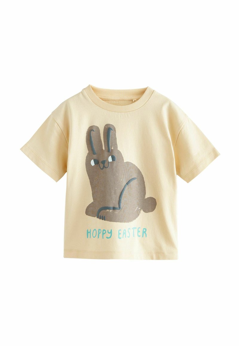 Krämfärgad bomull T-shirt med en grafik av en sittande brun kanin och texten "HOPPY EASTER" i turkos nedanför. Kort ärm.