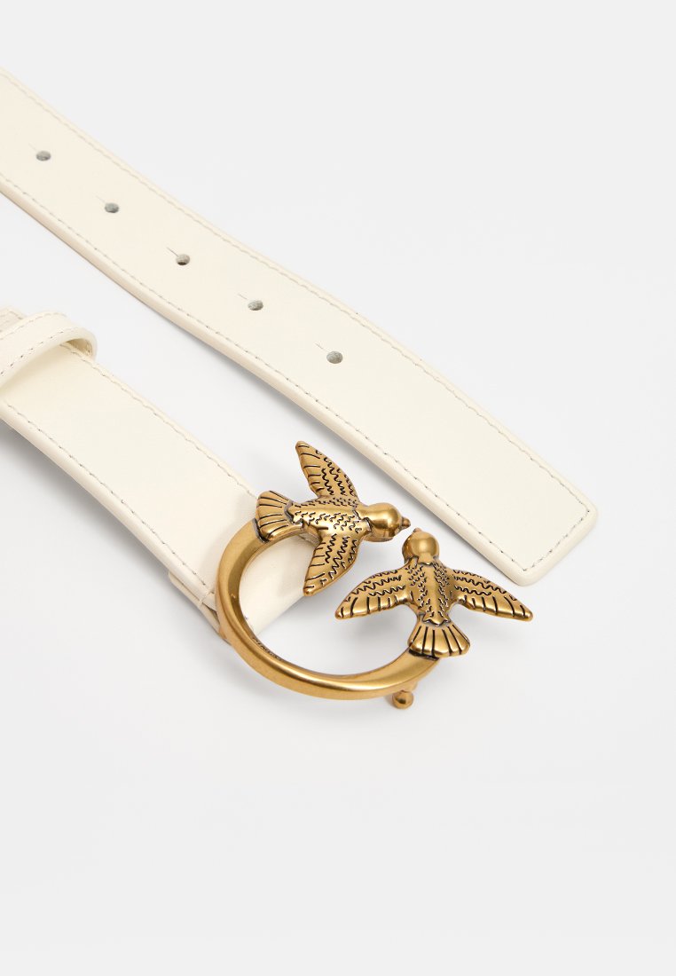 Cintura in pelle bianca con una fibbia circolare in tonalità oro raffigurante due uccelli dettagliati. La finitura testurizzata degli uccelli contrasta con la superficie liscia della cintura.