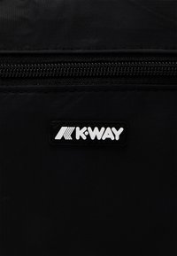 Black fabric bag featuring a visible zipper and a rectangular K-Way logo in white. The texture appears smooth and slightly glossy.