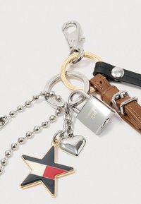 Keychain featuring a gold and black star charm, silver heart charm, a padlock, and assorted metal and leather straps in brown and black.