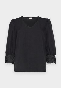 Blusa nera con scollo a V, maniche puff e accenti ricamati sui polsini. Realizzata in tessuto leggero con una finitura testurizzata.
