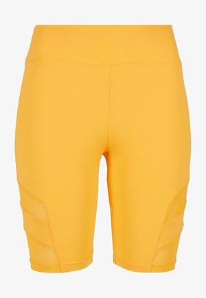 Gula cykelbyxor tillverkade av stretchy tyg, med en slät yta och meshpaneler på sidorna för extra ventilation.