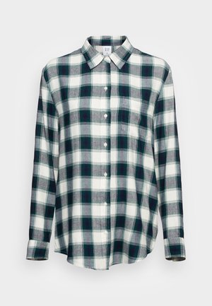 Chemise à manches longues boutonnée avec motif à carreaux vert et blanc et une poche poitrine, présentée sur un fond clair uni.