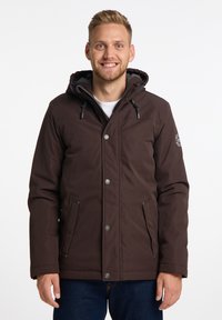 Giacca isolante marrone con cappuccio, dotata di bottoni a pressione, tasche laterali e dettagli con cordini. Realizzata in tessuto resistente all'acqua.