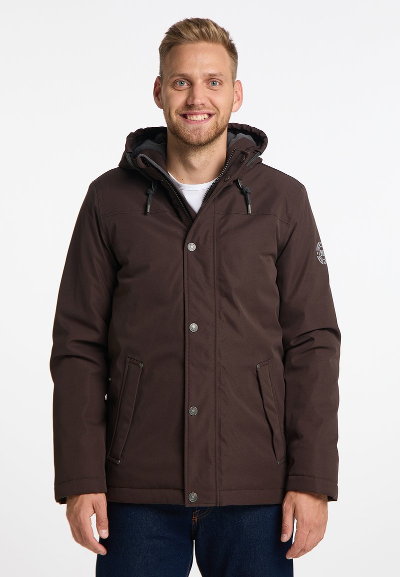 Giacca isolante marrone con cappuccio, dotata di bottoni a pressione, tasche laterali e dettagli con cordini. Realizzata in tessuto resistente all'acqua.