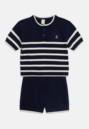 Navy blue and white striped short-sleeve knit shirt with two buttons and matching navy blue knit shorts for kids.