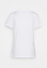 Bílý bavlněný tričko s klasickým kulatým výstřihem, krátkými rukávy a volným střihem. Na zadní straně nejsou viditelné vzory ani akcenty.