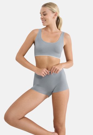 Gray seamless bralette and high-waisted shorts, featuring a smooth texture and a white trim. The design has a fitted, minimalistic shape.
