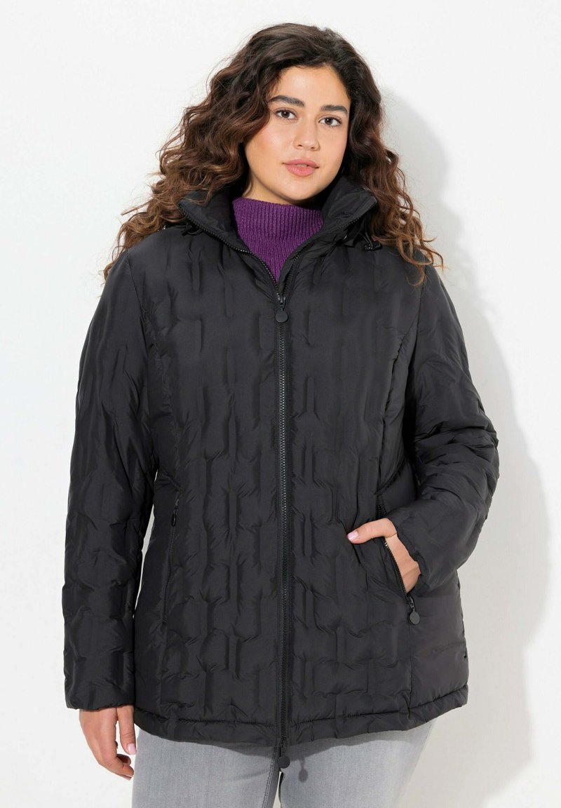 Svart puffjacka med dragkedja framtill, hög krage och strukturerad yta. Har två sidofickor och en något lös passform.