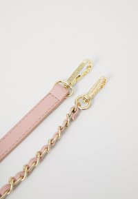 Correia de pele rosa com corrente de ouro e acessórios. Apresenta uma textura suave e fechos robustos para anexação.