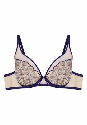 Underwire bra with beige mesh cups featuring black floral lace overlay, navy straps and band, and a small heart charm at the center.