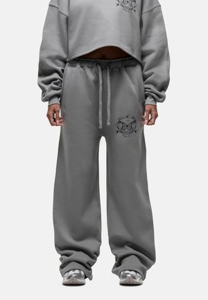 Grijze cropped sweatshirt met lange mouwen en een losse pasvorm, gecombineerd met bijpassende grijze sweatpants met een geborduurd detail op de dij.