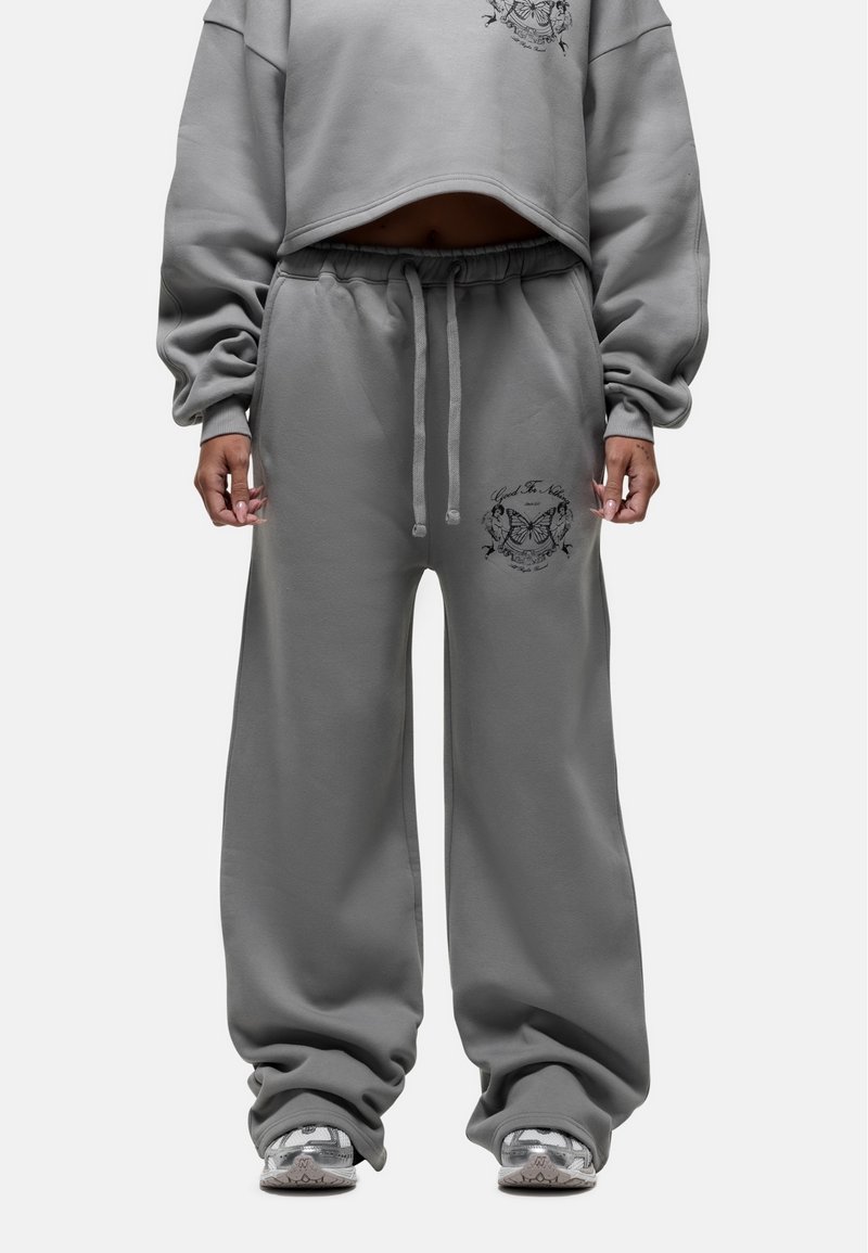 Grijze cropped sweatshirt met lange mouwen en een losse pasvorm, gecombineerd met bijpassende grijze sweatpants met een geborduurd detail op de dij.