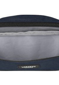 Sacchetto con zip in tessuto blu navy, con una fodera interna grigia. Presenta una zip nera e un'etichetta con la scritta "LARKSON HANDURO" sul lato.