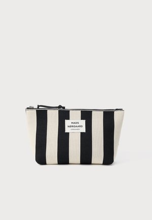 Csíkos vászontasak felváltva fekete és bézs csíkokkal, cipzáras záródással és "MADS NØRGAARD COPENHAGEN" felirattal ellátott címkével.