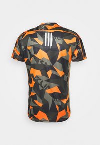 Camisa de manga corta con un patrón de camuflaje geométrico en tonos de verde, negro y naranja, con franjas blancas en la parte de atrás.