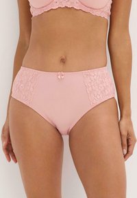 Rosa hochgeschnittene Panty mit Spitzen-Seitenpaneelen, einem glatten Körper und einem kleinen Schleifchen in der Mitte vorne. Weicher Stoff mit subtiler schimmernder Optik.