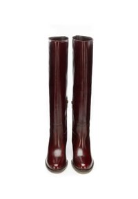 Bordowe skórzane kozaki do kolan o gładkim wykończeniu, zaokrąglonym nosku i subtelnych przeszyciach wzdłuż cholewki oraz bocznych zamków.