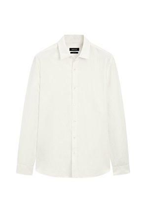 Camicia bianca a maniche lunghe con colletto a punta, chiusura frontale con bottoni e orlo dritto. Realizzata in tessuto leggero e testurizzato.