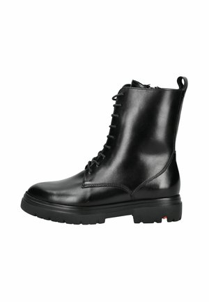 Bottines en cuir noir avec un bout rond, un laçage sur le devant, un col rembourré et une semelle en caoutchouc texturée. Dispose d'une languette à l'arrière.