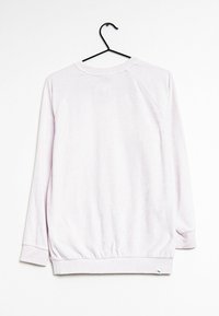 Sudadera rosa claro con mangas raglán largas, cuello redondo, puños y dobladillo acanalados. La tela parece suave con una textura sutil.