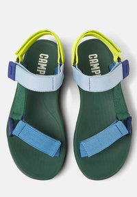Grønne sandaler med justerbare stropper i blå og gul. Har en tekstureret sål for godt greb og en kontureret form for komfort.